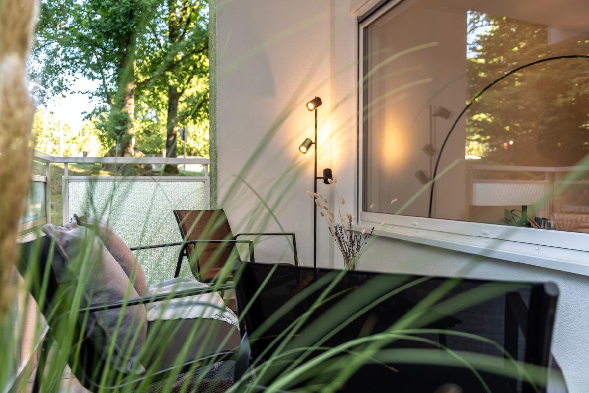 Balkon mit stilvollen Möbeln und Dekoration durch Home Staging